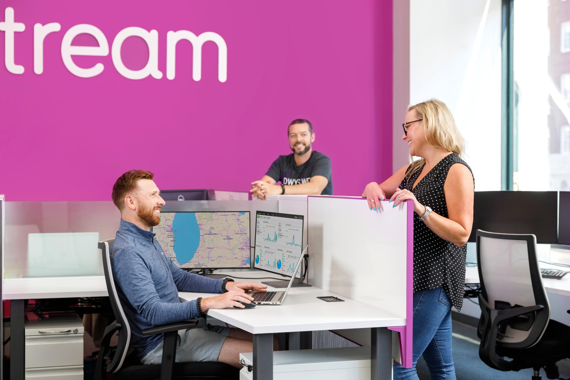 people chatting in the everstream office near an everstream logo sign